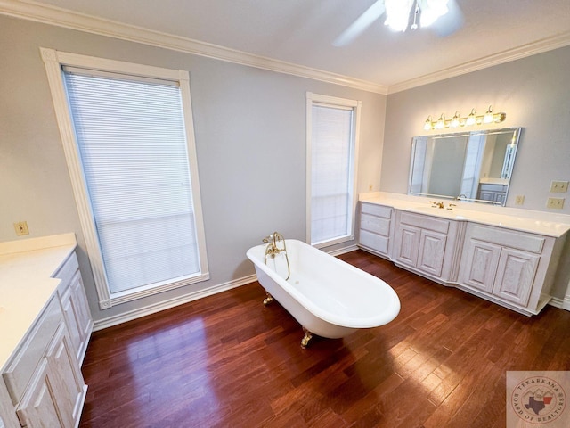 bathroom with crown molding, ceiling fan, hardwood / wood-style floors, a bathing tub, and vanity