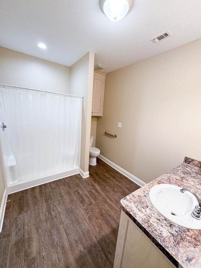 bathroom with vanity, toilet, and hardwood / wood-style floors