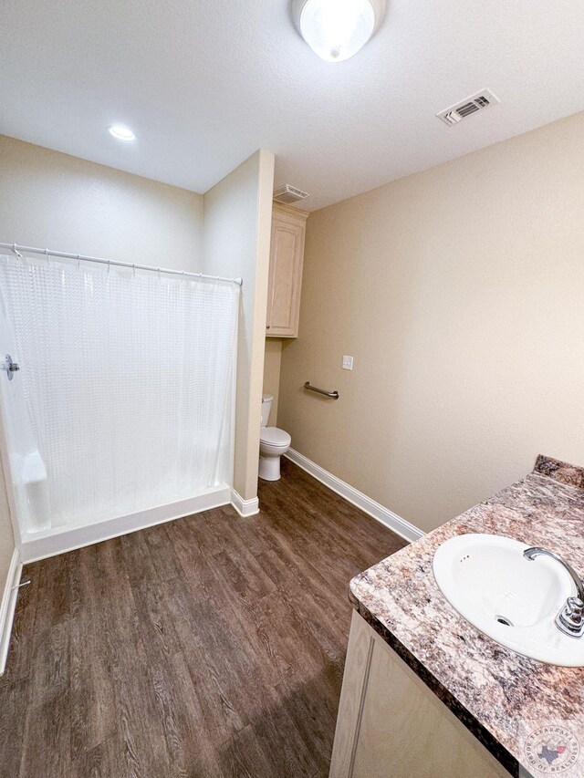 bathroom with vanity, toilet, and hardwood / wood-style floors