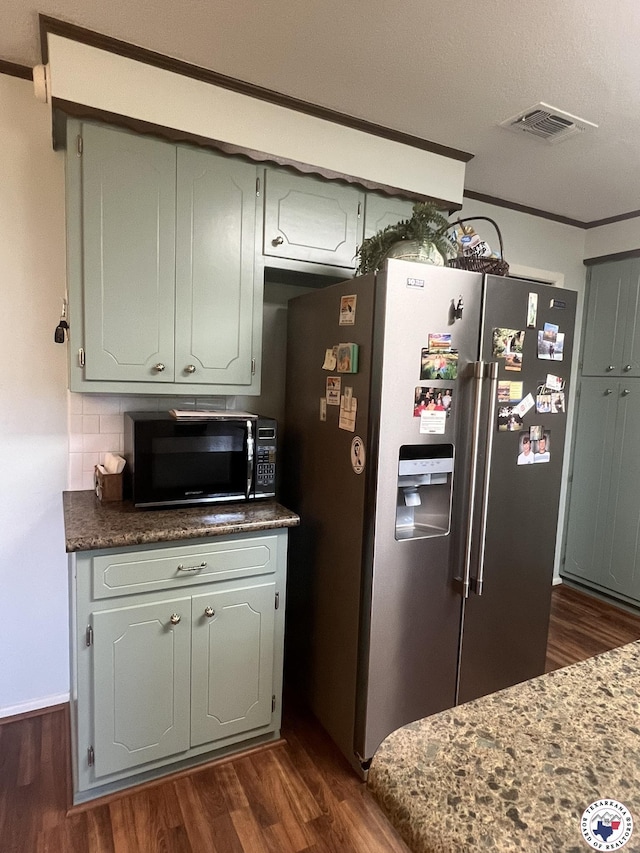 kitchen featuring high end refrigerator, black microwave, visible vents, and dark wood-style floors