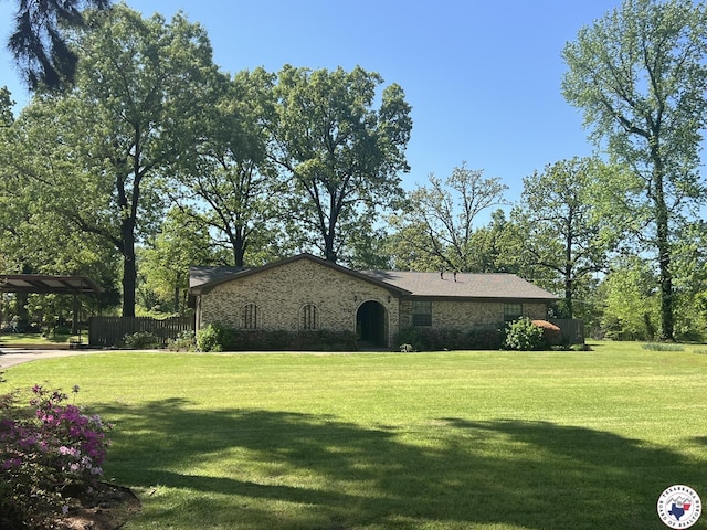view of home's exterior with a detached carport and a lawn