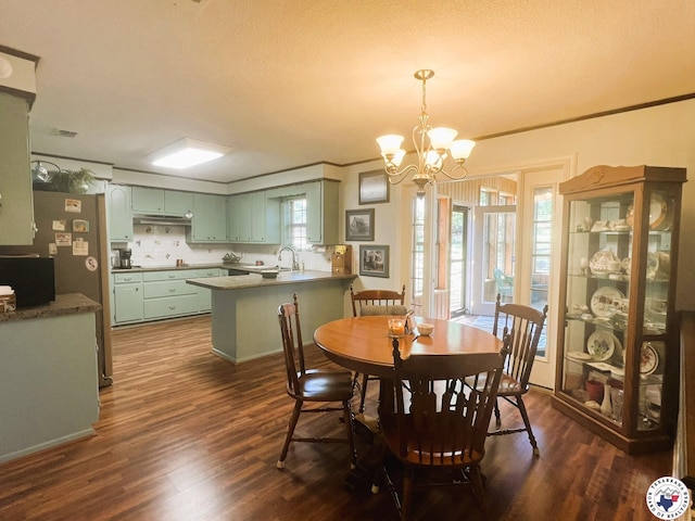dining room with dark wood-type flooring, a notable chandelier, and ornamental molding