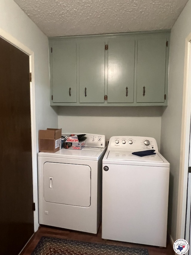 washroom with dark wood-style floors, washing machine and dryer, a textured ceiling, and cabinet space