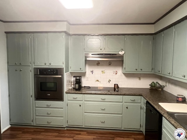kitchen featuring dark wood-type flooring, green cabinets, decorative backsplash, and black appliances