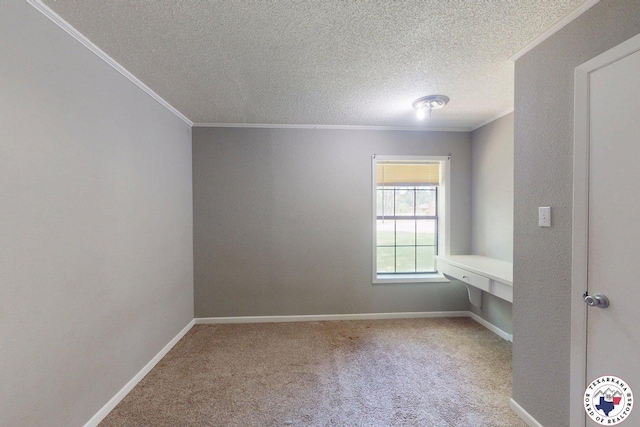 empty room featuring baseboards, ornamental molding, a textured ceiling, and carpet
