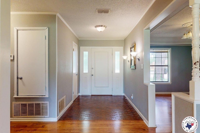 entrance foyer with visible vents, a textured ceiling, baseboards, and wood finished floors