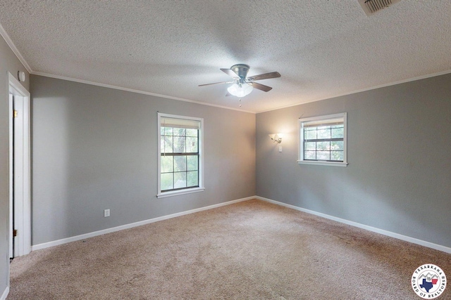 carpeted spare room featuring a ceiling fan, a textured ceiling, visible vents, crown molding, and baseboards