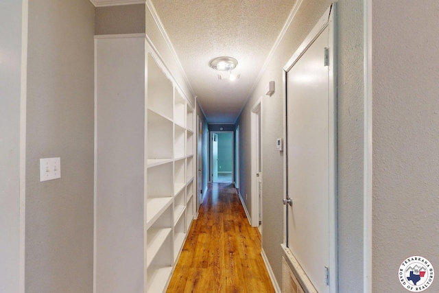 hall with a textured ceiling and light wood-type flooring