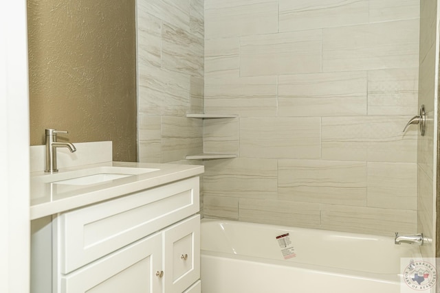 bathroom with tiled shower / bath combo and vanity