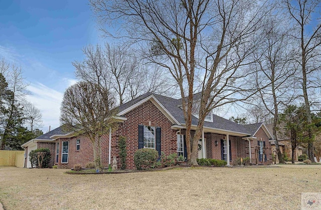 view of front of property featuring brick siding, an attached garage, and a front yard