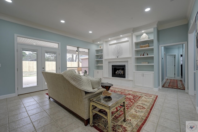 living room featuring recessed lighting, built in shelves, a fireplace with raised hearth, and crown molding