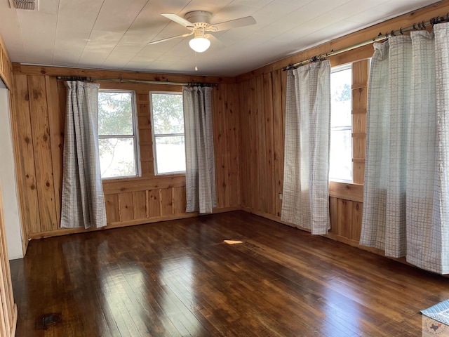 unfurnished room featuring wood walls and dark wood-type flooring