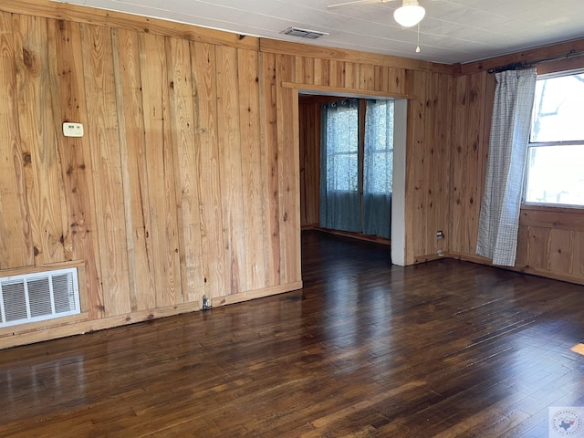 spare room featuring wooden walls and dark hardwood / wood-style flooring