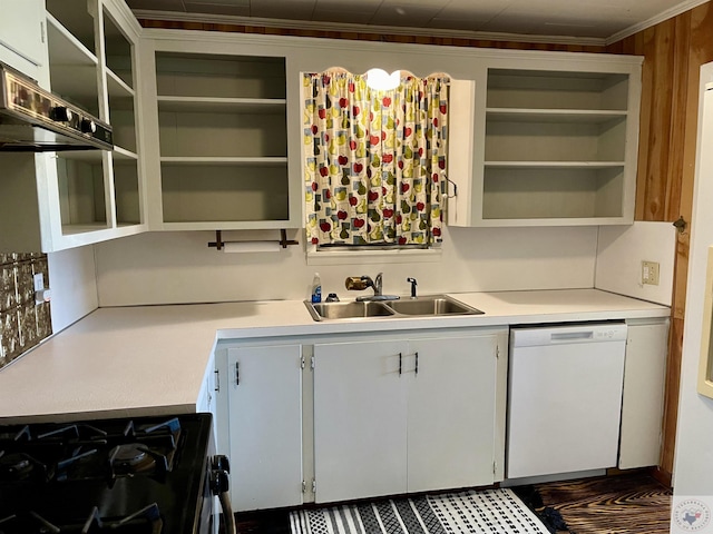 kitchen with dishwasher, gas range, sink, white cabinets, and wood walls