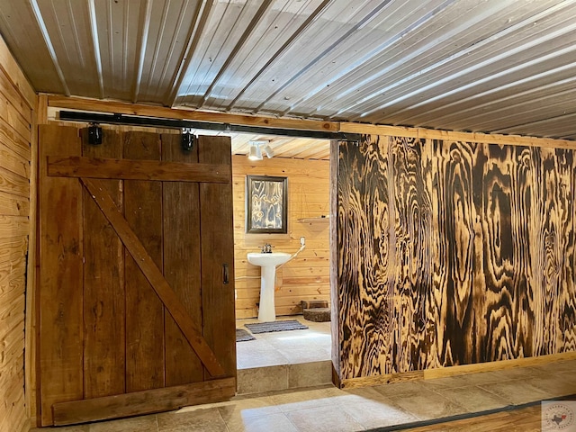 bathroom with sink, wood walls, and wooden ceiling