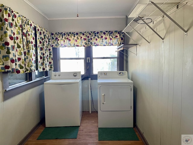 laundry room featuring wood walls, ornamental molding, dark hardwood / wood-style floors, and washer and dryer