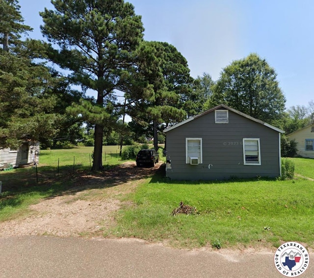 view of side of property with a lawn and cooling unit