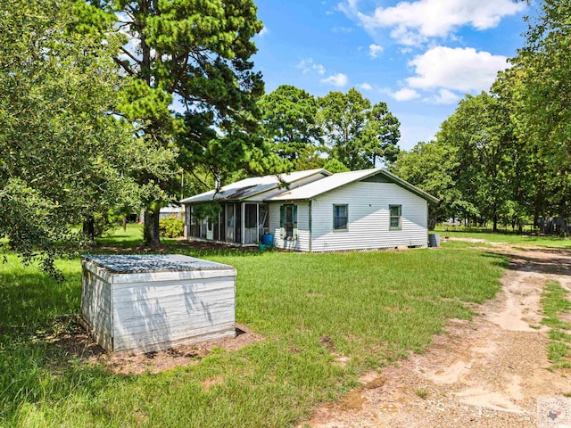 rear view of house with a yard and a sunroom