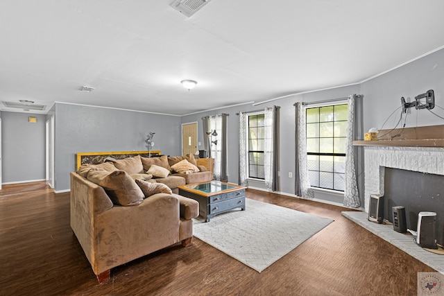 living room with a brick fireplace, dark wood-type flooring, and ornamental molding