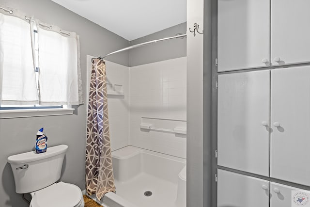 bathroom featuring toilet and a shower with curtain