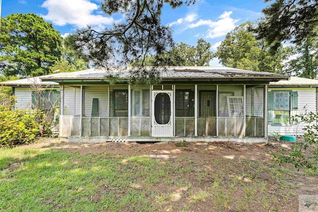 view of front of house featuring a sunroom and a front yard