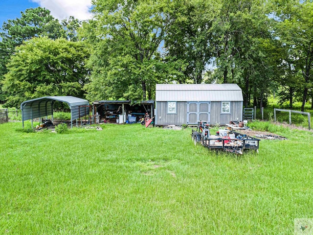 view of yard featuring a carport and a storage unit