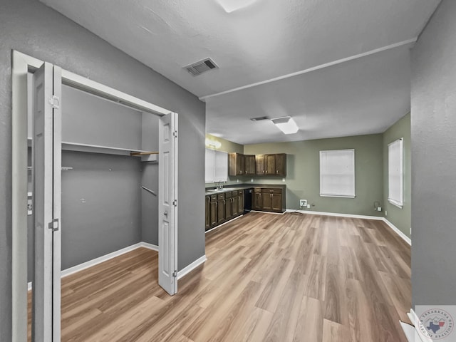 kitchen featuring sink, dark brown cabinets, light wood-type flooring, and dishwasher