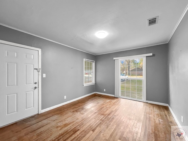 spare room with hardwood / wood-style floors and crown molding