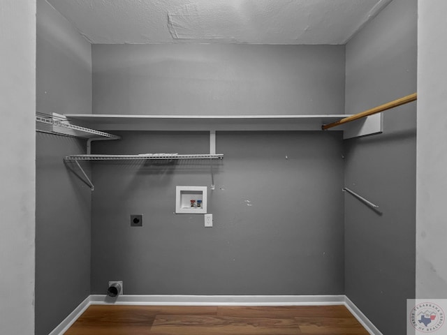 clothes washing area with wood-type flooring, electric dryer hookup, a textured ceiling, and hookup for a washing machine