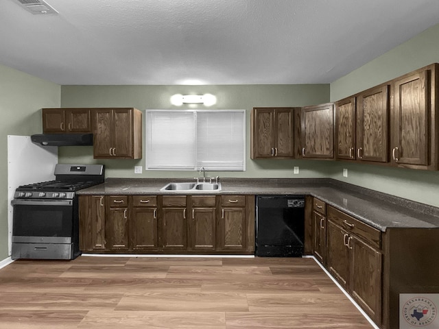 kitchen featuring dishwasher, sink, light wood-type flooring, stainless steel gas range oven, and dark brown cabinetry