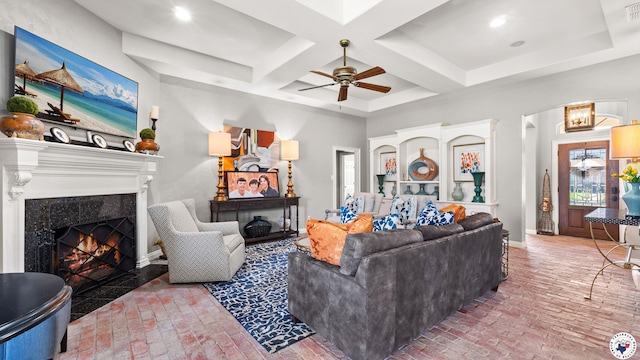 6914 Manor Crest Dr, Texarkana, AR 71854 - living room with brick floors, a ceiling fan, a high end fireplace, coffered ceiling, and beamed ceiling