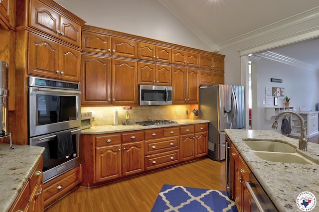 16 Bill Rogers Dr, Texarkana, TX 75503 - kitchen with stainless steel appliances, a sink, lofted ceiling, light wood-type flooring, and backsplash
