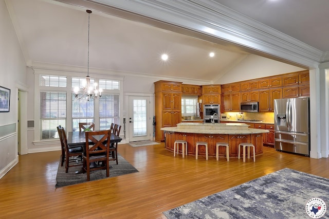 16 Bill Rogers Dr, Texarkana, TX 75503 - kitchen with stainless steel appliances, a chandelier, ornamental molding, vaulted ceiling, and brown cabinetry