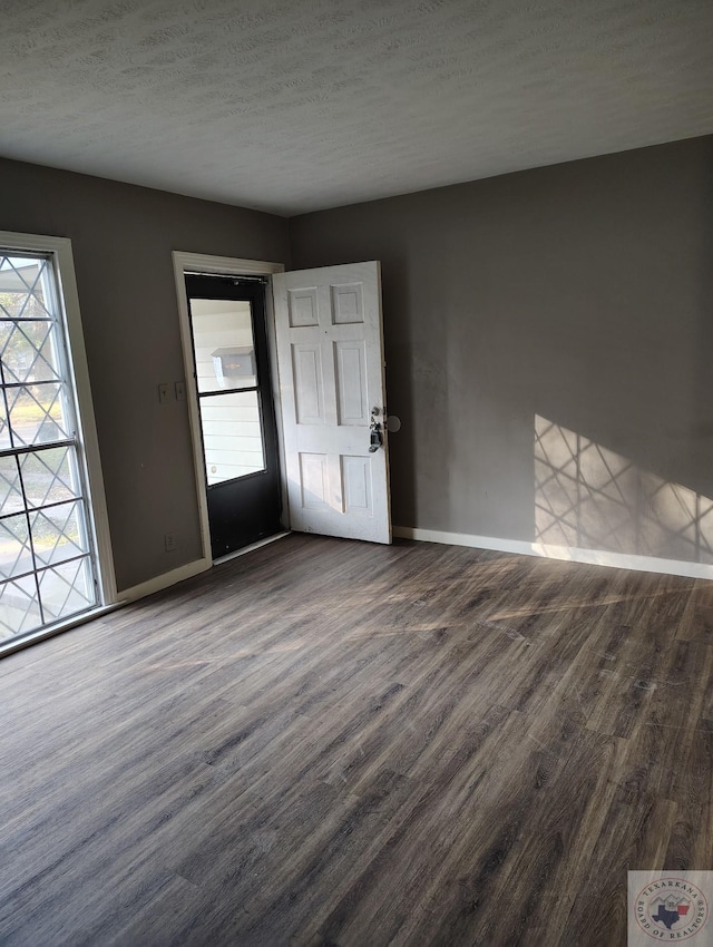 interior space featuring a textured ceiling and dark hardwood / wood-style floors