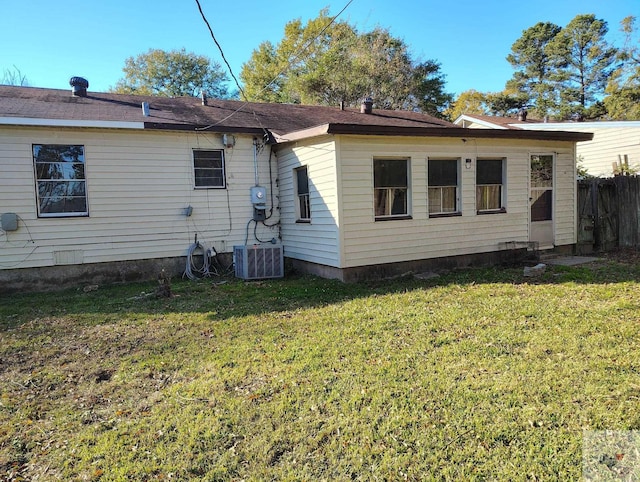 back of house featuring a yard and central AC