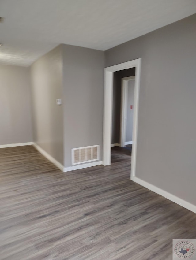 unfurnished room with dark wood-type flooring