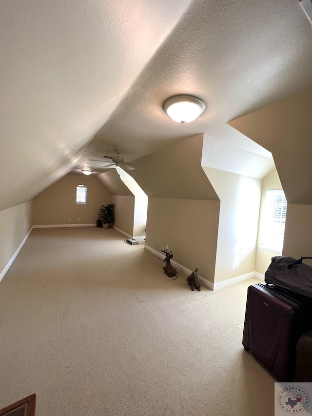 bonus room with a textured ceiling, carpet floors, and vaulted ceiling