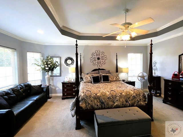 bedroom with light carpet, a tray ceiling, ceiling fan, and crown molding