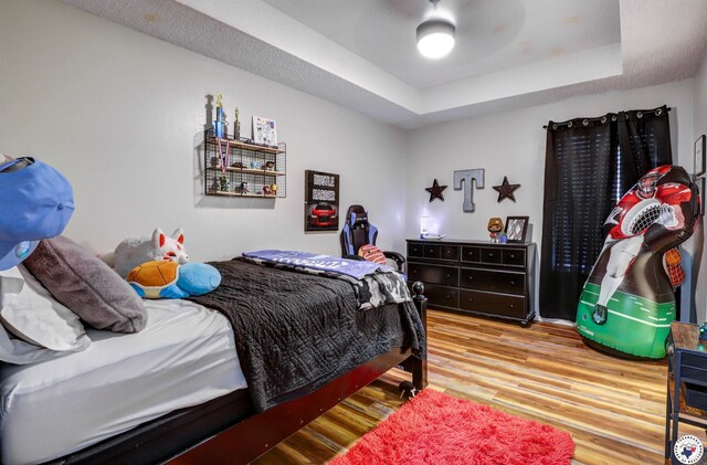 3502 Tiffany Ln, Texarkana, AR 71854 - bedroom featuring wood finished floors, a raised ceiling, and ceiling fan