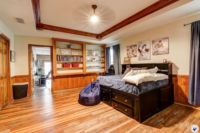 3502 Tiffany Ln, Texarkana, AR 71854 - bedroom featuring a wainscoted wall, hardwood / wood-style floors, wood walls, ornamental molding, and a tray ceiling