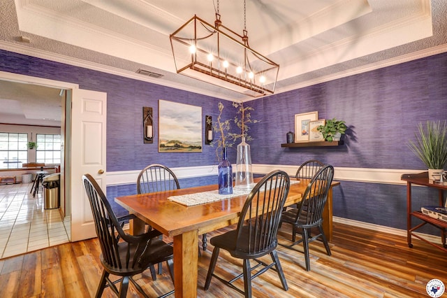 3502 Tiffany Ln, Texarkana, AR 71854 - dining space featuring a raised ceiling, wood-type flooring, a chandelier, wainscoting, and ornamental molding