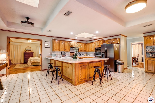 3502 Tiffany Ln, Texarkana, AR 71854 - kitchen with a skylight, stainless steel fridge, a raised ceiling, a peninsula, and a breakfast bar area