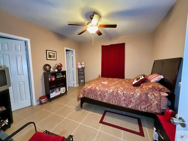 tiled bedroom with a textured ceiling and ceiling fan