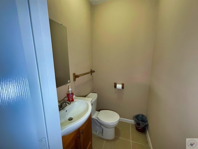 bathroom with toilet, vanity, and tile patterned flooring