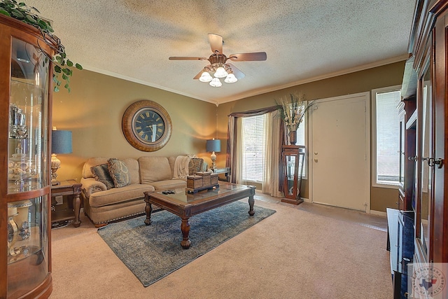 living room featuring ceiling fan, light colored carpet, a textured ceiling, and crown molding