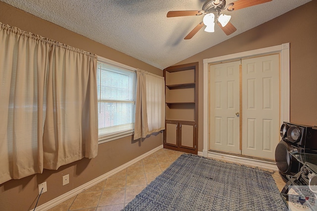 bedroom with lofted ceiling, a textured ceiling, a closet, and ceiling fan