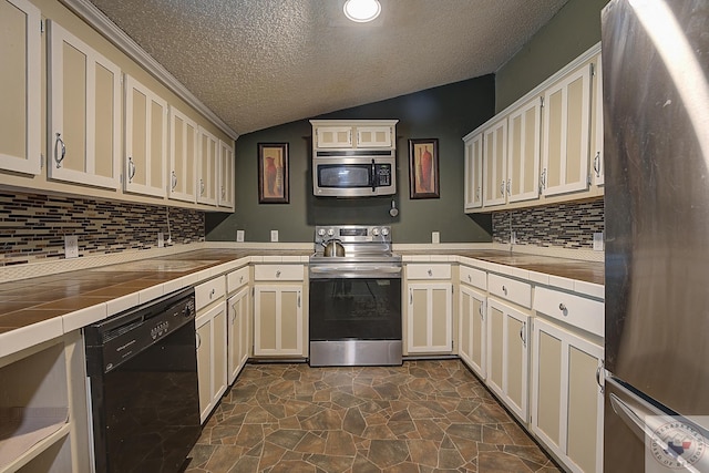 kitchen with cream cabinets, tile counters, appliances with stainless steel finishes, and tasteful backsplash