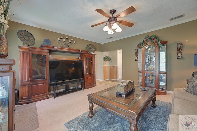 carpeted living room with crown molding, a textured ceiling, and ceiling fan