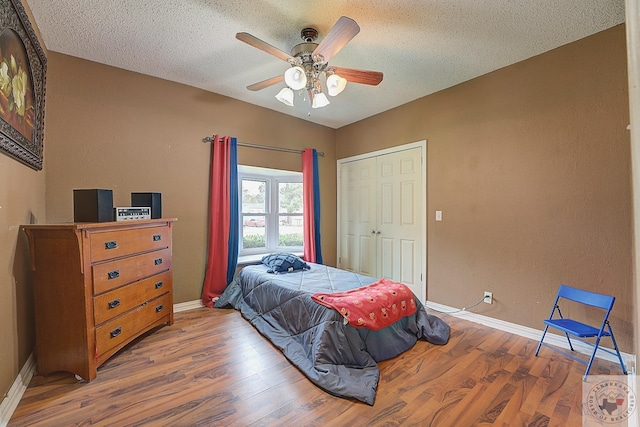 bedroom featuring ceiling fan, a textured ceiling, and hardwood / wood-style flooring