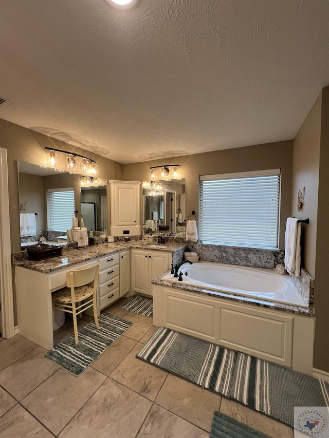 bathroom featuring a washtub, a textured ceiling, tile patterned floors, and vanity